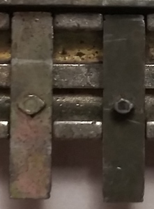 Two different slider nubs, one larger and diamond-shaped, the other smaller and circular